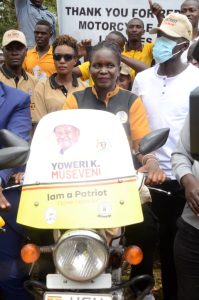 The Commissioner for National Secretariat for Patriotism Corps-NSPC Ms Hellen Seku on a Motorcycle.